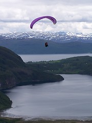 Image showing Paragliding over sea with mountains in the background