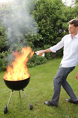 Image showing BBQ with fire an young man