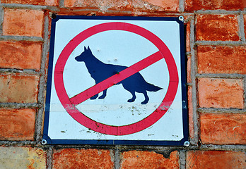Image showing Sign prohibiting walk out dogs in park on red brick house wall 