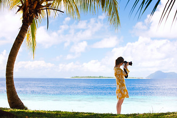 Image showing Young woman taking photos at beach