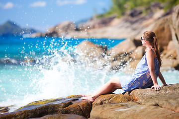 Image showing Young woman relaxing on rocky coast