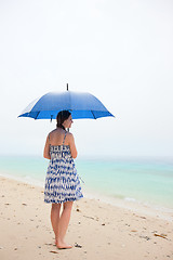 Image showing Woman at beach under rain