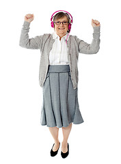 Image showing Cheerful aged woman enjoying music