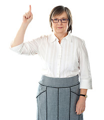 Image showing Beautiful senior business lady pointing upwards