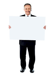 Image showing Businessman holding a blank billboard