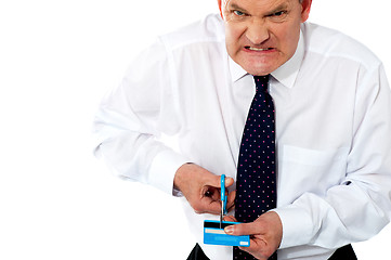 Image showing Frustrated businessman cutting his credit card