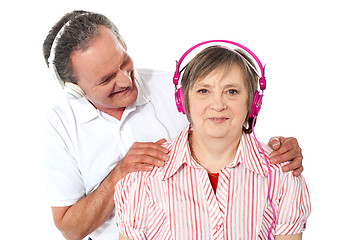 Image showing Aged couple enjoying music over white background