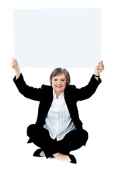 Image showing Seated businesswoman holding blank whiteboard