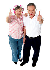 Image showing Thumbs-up couple tuned into music