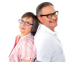 Image showing Portrait of smiling aged couple posing back to back