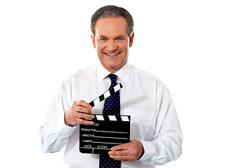 Image showing Aged corporate male holding clapperboard