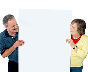 Image showing Old age couple presenting banner together