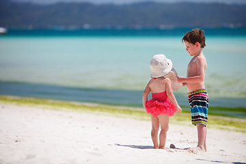 Image showing Two adorable kids standing by ocean shore