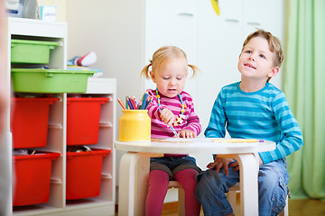 Image showing Two kids drawing with coloring pencils