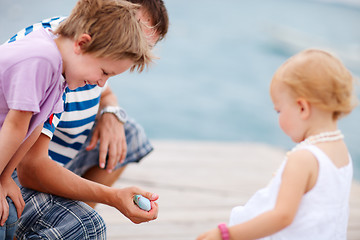 Image showing Father showing his kids a fish.