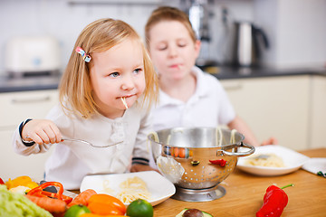 Image showing Two kids eating spaghetti