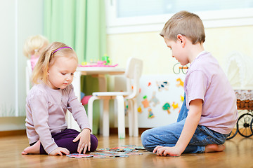 Image showing Brother and sister solving puzzle