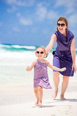 Image showing Mother and daughter running at beach
