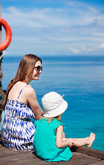 Image showing Mother and daughter sitting on wooden dock