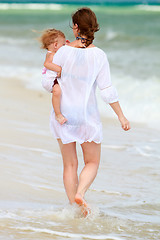 Image showing Mother and baby walking along beach