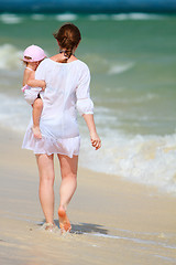 Image showing Mother and baby walking along tropical beach