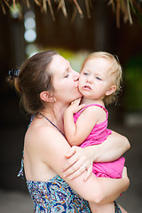 Image showing Mother kissing her little daughter