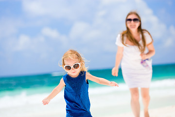 Image showing Mother and daughter running at beach