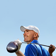 Image showing Smiling golfer holding golf club over shoulder 