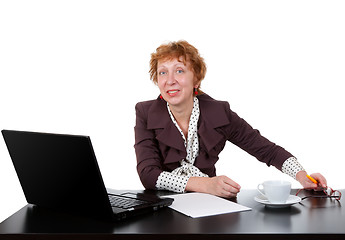 Image showing Middle-aged woman at the table, a laptop