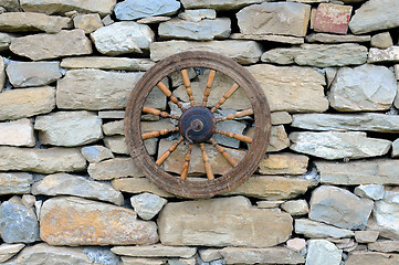 Image showing Vintage Spinning Wheel on Stone Wall