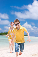 Image showing Mother and son running at beach