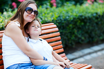 Image showing Mother and son sitting on bench