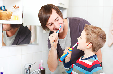 Image showing Father and son brushing teeth