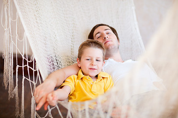 Image showing Father and son relaxing in hammock