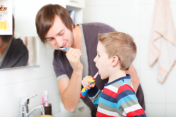 Image showing Father and son brushing teeth