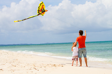 Image showing Father and son flying kite on beach 