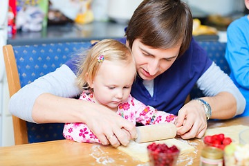 Image showing Toddler girl and her dad baking pie