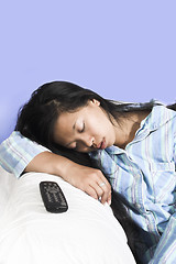 Image showing woman sleeping on couch with remote aside