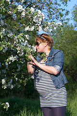 Image showing Pregnant woman sniffing flower