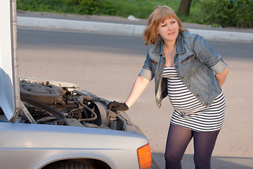 Image showing Pregnant Woman Trying to Repair the Car