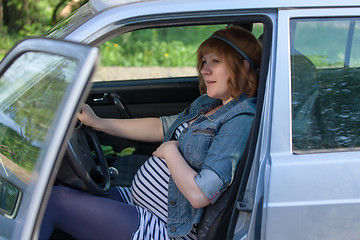 Image showing Pregnant woman speaking to her belly in the car