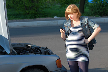 Image showing Pregnant Woman Calling for help near the Broken Car