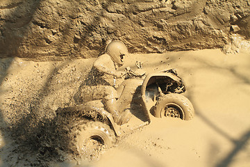 Image showing man badly stuck in mud with his quadbike