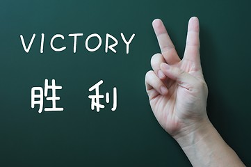 Image showing Victory gesture on a blackboard background