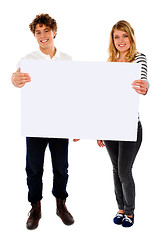 Image showing Adorable young couple promoting blank banner ad