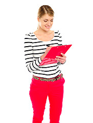 Image showing Young girl writing makes notes on clipboard