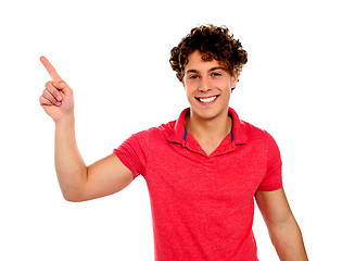 Image showing Handsome young teenager in casuals pointing away