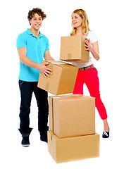 Image showing A young couple holds boxes in studio