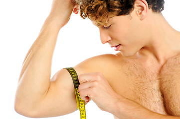 Image showing Handsome guy measuring his biceps