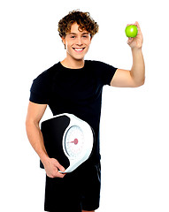 Image showing Fit guy with weighing scale and green apple